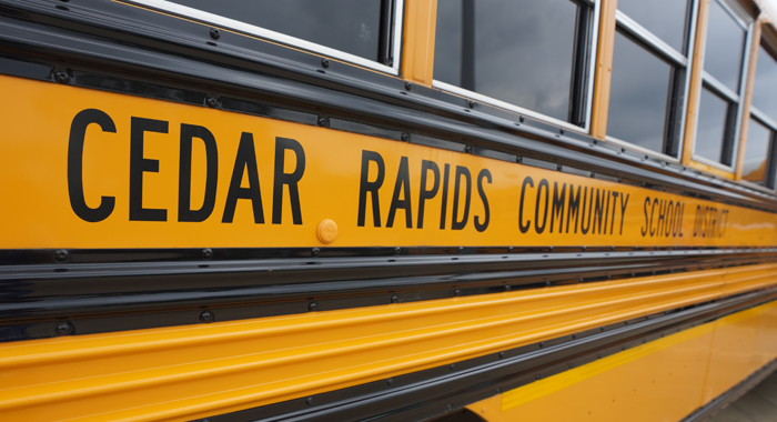 Outside of a school district bus that says, Cedar Rapids