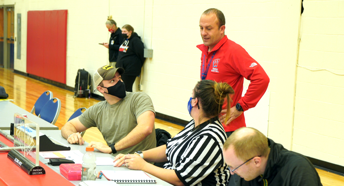 Grant Schultz talks with the score table personal before a basketball game.