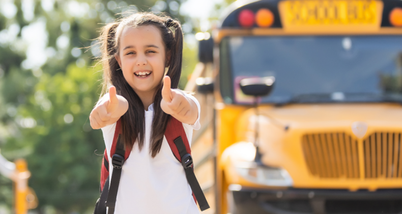 A bus riding student giving two thumbs up!