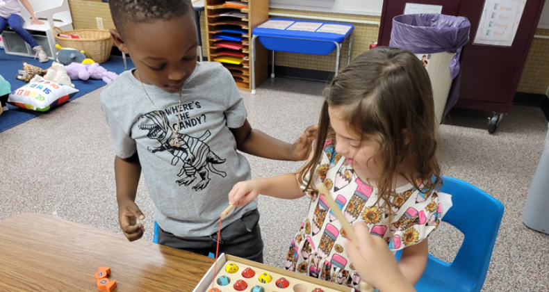 Two preschoolers play a game together.