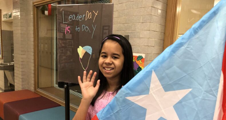 student waving near flag