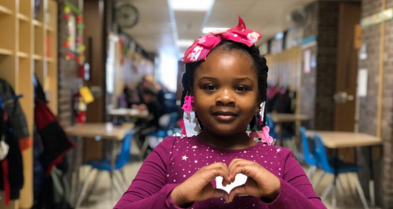 female student making heart shape with hands