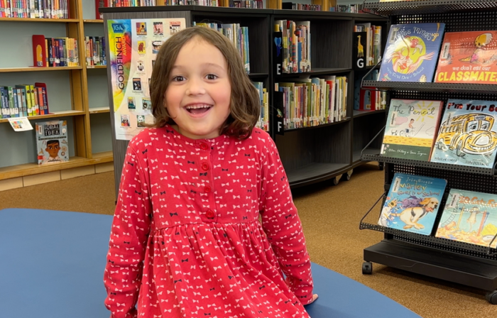 A kindergarten student smiles and is happy.