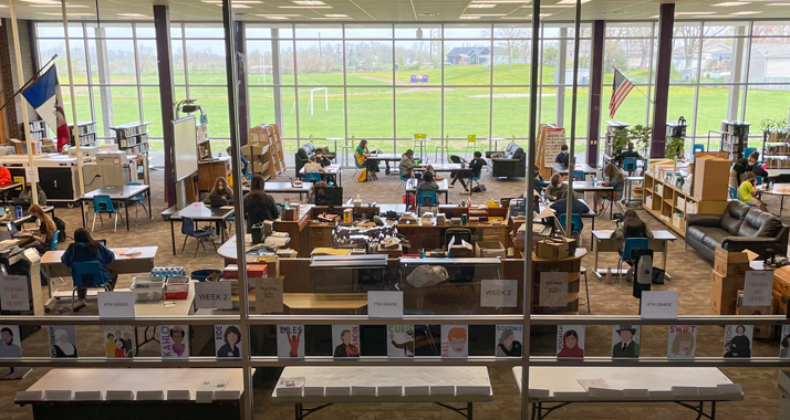 Looking through the windows to a schools IMC where students are working