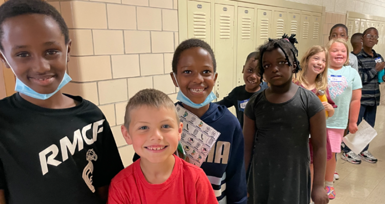 Students smiling in the hallway.